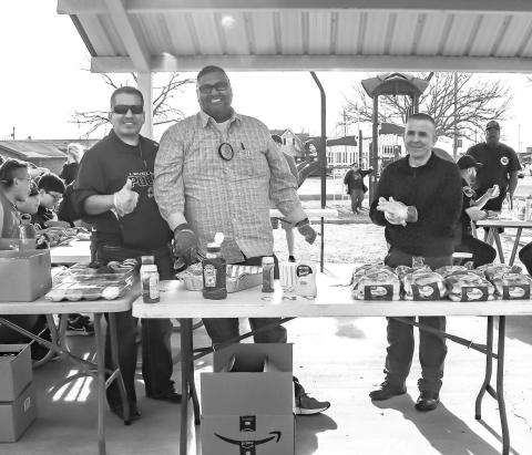 SERVICE WITH A SMILE- The Levelland Police Department hosted their first “Cops and Communities” Thursday at the Kauffman Park. Pictured from right to left are: Detectives Lopez, Ramirez and Whooten preparing food for community members and first responders attending the event. (Staff photo by Essence Childers)