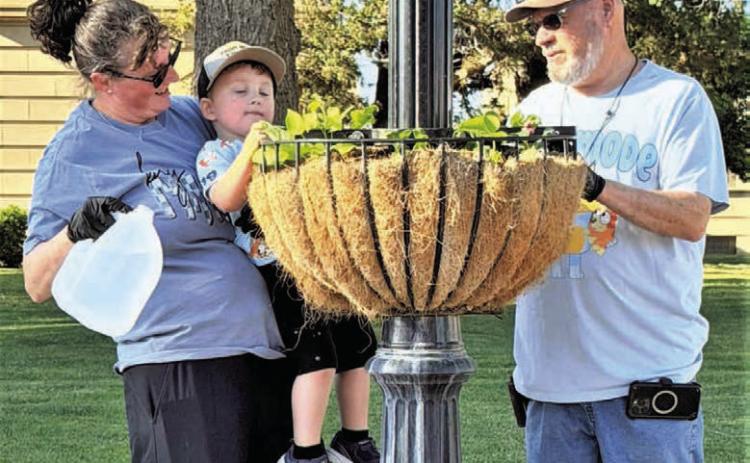 DRINK UP- Community members worked this past Saturday cleaning out planters containing the spring plants and adding live plants for the summer months. (City of Levelland Main Street photo)